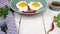 Putting two fried egg with yolk and smile, in blue plate and give breakfast on wooden kitchen table.