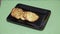 Putting zucchini pancakes with sour cream on a rectangular black plate, serving dishes cooking baking healthy