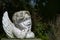 Putto or child angel statue of ceramic with flaking white paint