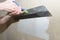 Puttying the wall with plaster putty using a wide spatula
