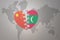 Puzzle heart with the national flag of china and maldives on a world map background. Concept