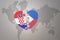 Puzzle heart with the national flag of croatia and philippines on a world map background.Concept