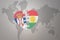 Puzzle heart with the national flag of kurdistan and serbia on a world map background.Concept