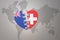 Puzzle heart with the national flag of new zealand and switzerland on a world map background. Concept