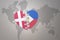 Puzzle heart with the national flag of philippines and denmark on a world map background. Concept