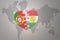 Puzzle heart with the national flag of portugal and kurdistan on a world map background.Concept