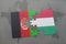 puzzle with the national flag of afghanistan and hungary on a world map background.