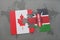 puzzle with the national flag of canada and kenya on a world map background.