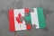 puzzle with the national flag of canada and nigeria on a world map background.