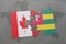 puzzle with the national flag of canada and togo on a world map background.