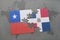 puzzle with the national flag of chile and dominican republic on a world map background.