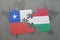 puzzle with the national flag of chile and hungary on a world map background.