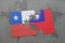 puzzle with the national flag of chile and taiwan on a world map background.