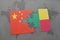puzzle with the national flag of china and benin on a world map background.