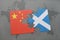 puzzle with the national flag of china and scotland on a world map background.