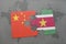 puzzle with the national flag of china and suriname on a world map background.