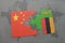 puzzle with the national flag of china and zambia on a world map background.
