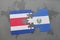 puzzle with the national flag of costa rica and el salvador on a world map background.