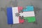 puzzle with the national flag of france and uzbekistan on a world map background.