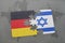 puzzle with the national flag of germany and israel on a world map background.