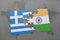 puzzle with the national flag of greece and india on a world map background.