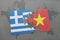 puzzle with the national flag of greece and vietnam on a world map background.