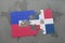 puzzle with the national flag of haiti and dominican republic on a world map background.