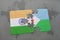 puzzle with the national flag of india and djibouti on a world map background.