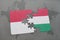 puzzle with the national flag of indonesia and hungary on a world map background.