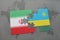 puzzle with the national flag of iran and rwanda on a world map background.