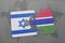 puzzle with the national flag of israel and gambia on a world map background.