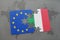 puzzle with the national flag of italy and european union on a world map