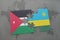 puzzle with the national flag of jordan and rwanda on a world map background.