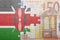 Puzzle with the national flag of kenya and euro banknote