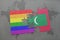 puzzle with the national flag of maldives and gay rainbow flag on a world map background.