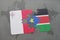 puzzle with the national flag of malta and south sudan on a world map