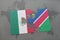puzzle with the national flag of mexico and namibia on a world map background.