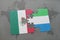 puzzle with the national flag of mexico and sierra leone on a world map background.