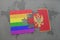 puzzle with the national flag of montenegro and gay rainbow flag on a world map background.