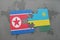 puzzle with the national flag of north korea and rwanda on a world map