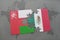 puzzle with the national flag of oman and mexico on a world map background.