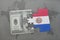 puzzle with the national flag of paraguay and dollar banknote on a world map background.