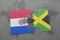 puzzle with the national flag of paraguay and jamaica on a world map background.