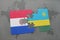 puzzle with the national flag of paraguay and rwanda on a world map