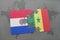 puzzle with the national flag of paraguay and senegal on a world map