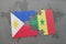 puzzle with the national flag of philippines and senegal on a world map