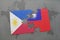 puzzle with the national flag of philippines and taiwan on a world map background.