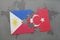 puzzle with the national flag of philippines and turkey on a world map background.