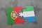 puzzle with the national flag of portugal and sierra leone on a world map background.