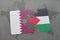 puzzle with the national flag of qatar and palestine on a world map background.